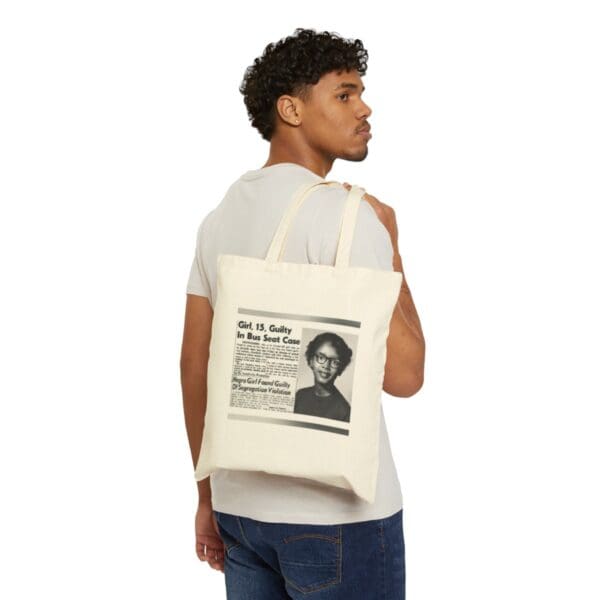 Man carrying a tote bag with a newspaper clipping.