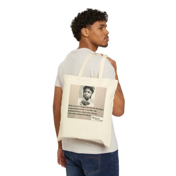 Man holding tote bag with Rebecca Lee Crumpler image.