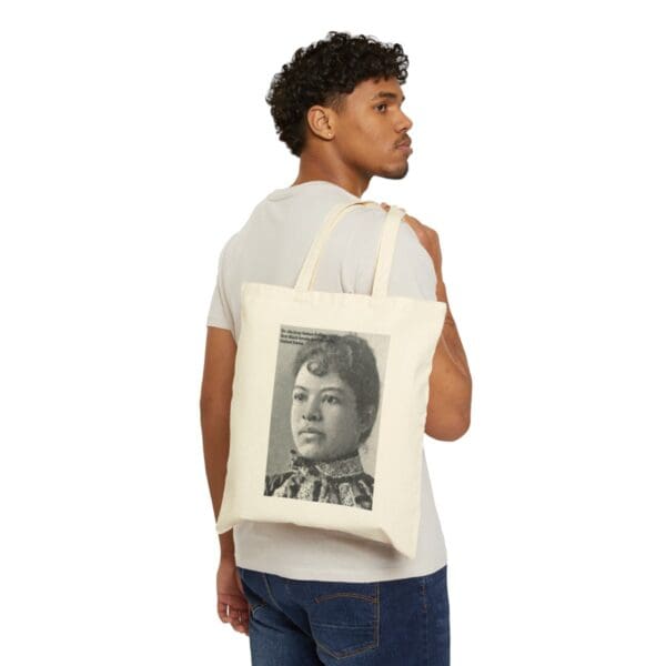 Man carrying a tote bag with a woman's portrait.