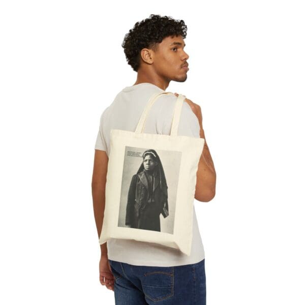 Man carrying a tote bag with a woman on it.