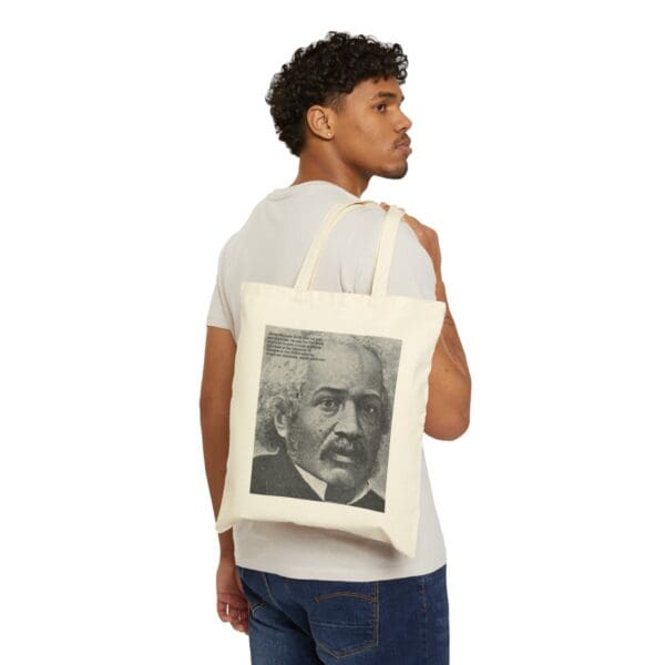 Man carrying a tote bag with a portrait of a man.