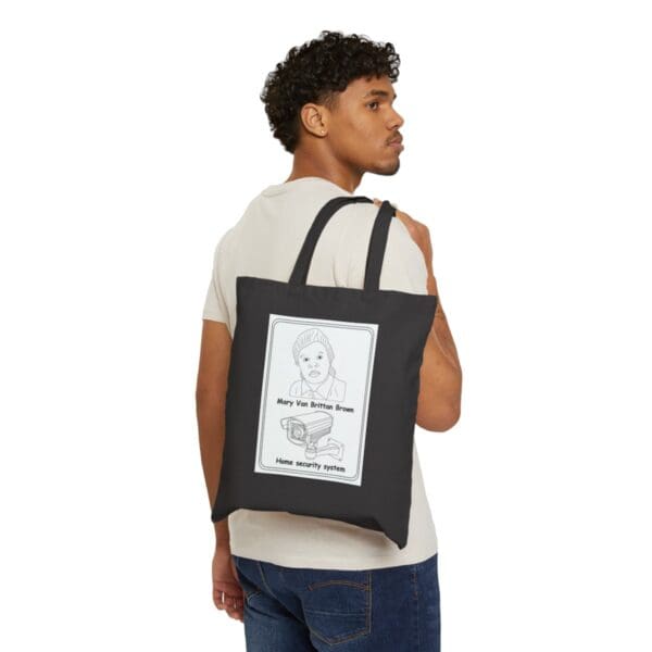 Man carrying a black tote bag with a security system design.