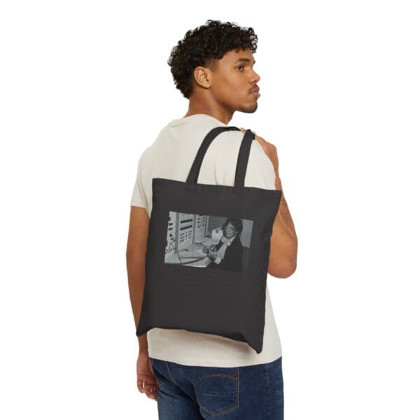 Man wearing black tote bag with woman on phone.