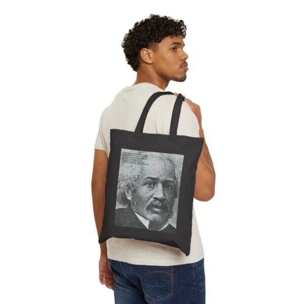 Man carrying black tote bag with portrait.