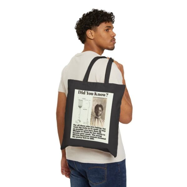 Man wearing a black tote bag with a quote about Anna Mangin.