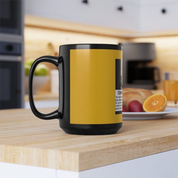 Black coffee mug with yellow text.