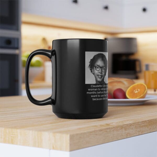 Black mug with a photo of Claudette Colvin.