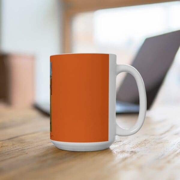 Orange and white mug on a table.