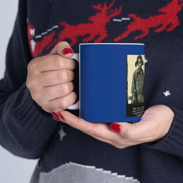 Hands holding a blue mug with a girl on it.