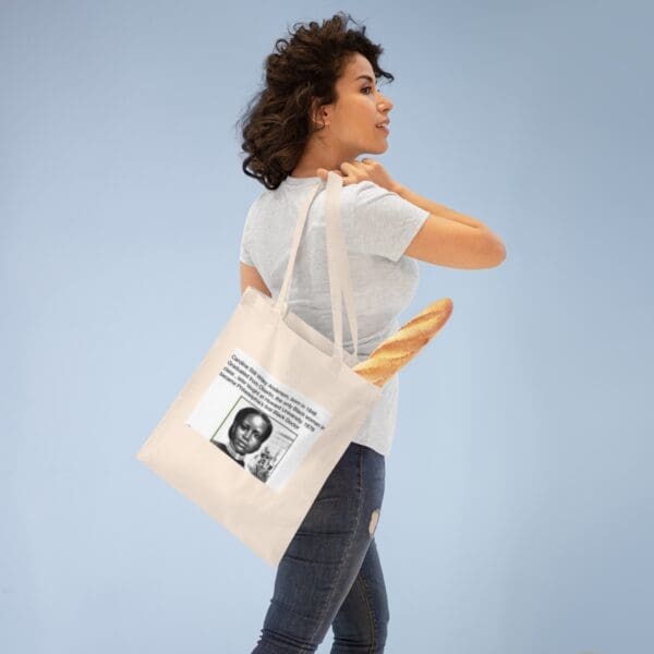 Woman holding a tote bag with a historical quote.