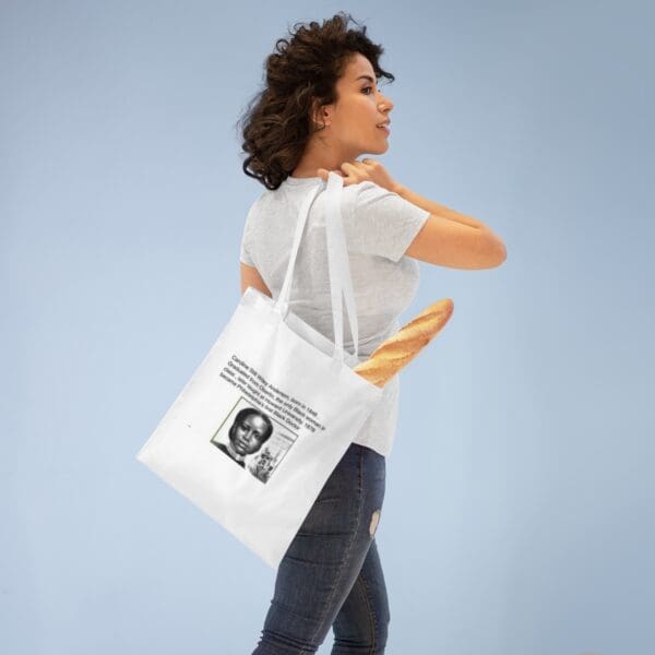 Woman holding a tote bag with a portrait.