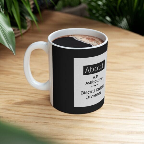 Black mug with text about biscuit cutter inventor.