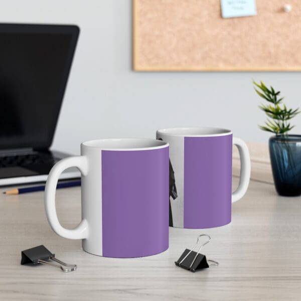 Two purple and white coffee mugs on a desk.