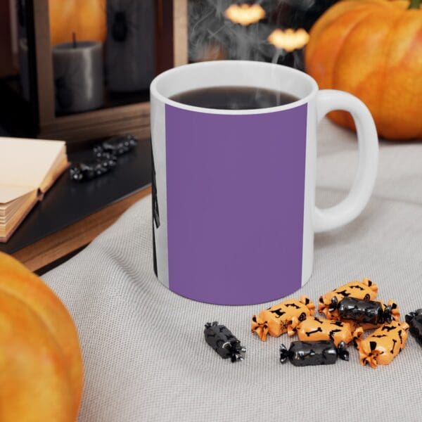 Purple mug with coffee and Halloween candy.