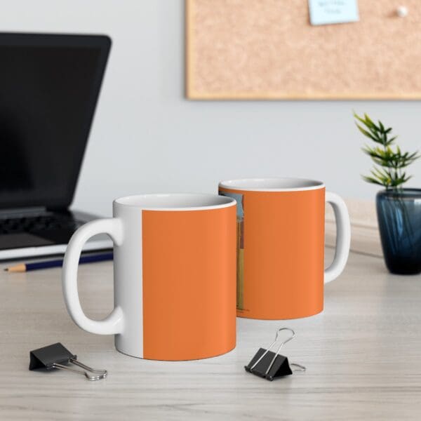 Two orange mugs on a wooden table.