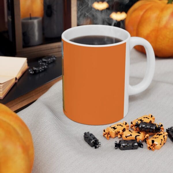 Orange mug with coffee and candy corn.