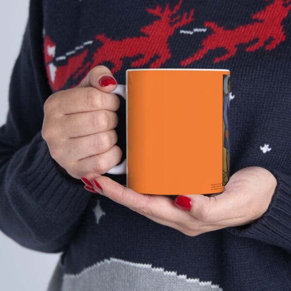 Person holding an orange coffee mug.