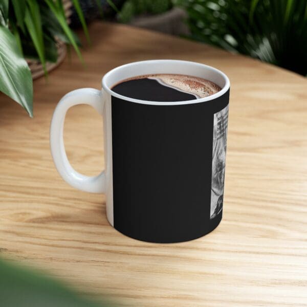 Black mug with coffee and text on side.