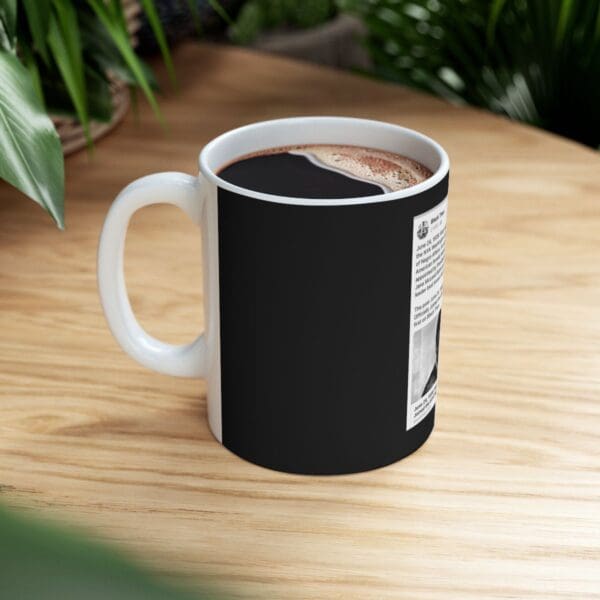 Black coffee mug with news article.