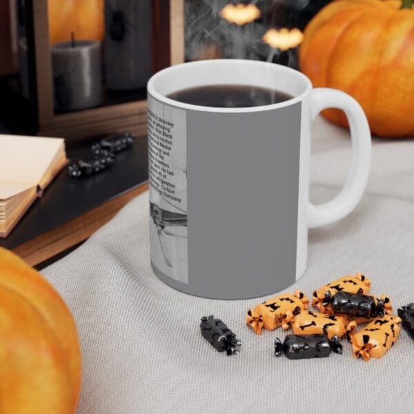 Gray coffee mug with black and orange candies.