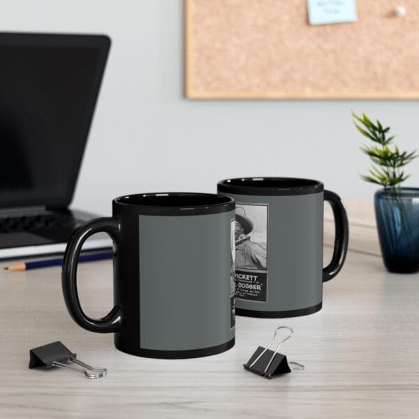 Black coffee mug with a vintage poster image.