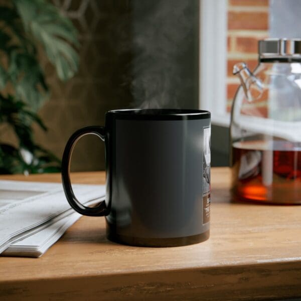 Black mug with steam on a wooden table.