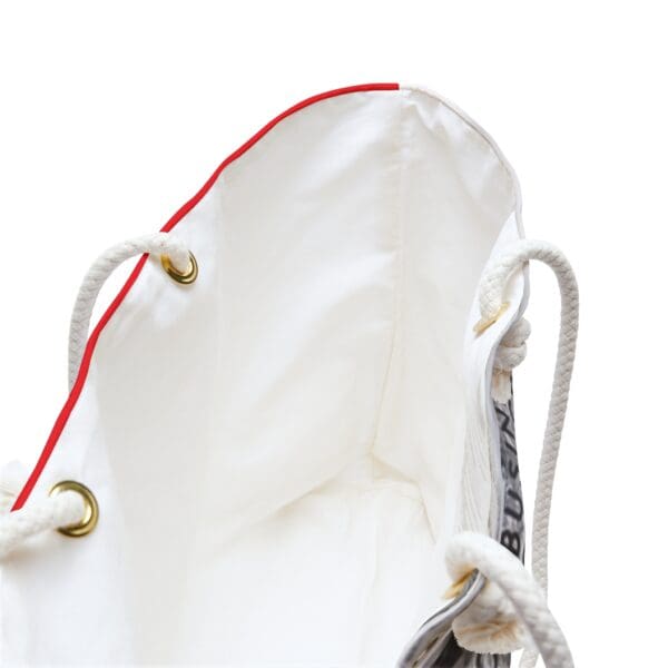 White tote bag with red trim and rope handles.