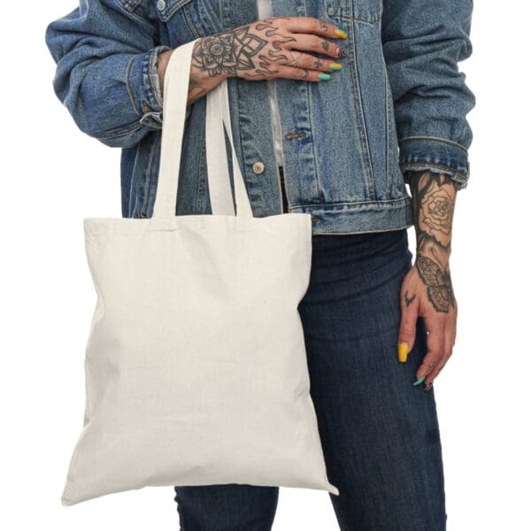 Person holding a blank white tote bag.