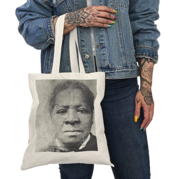 Woman holding a tote bag with a portrait.