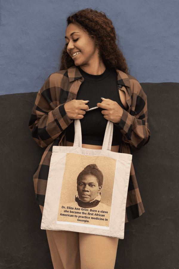 Woman holding tote bag with Dr. Eliza Ann Grier portrait.