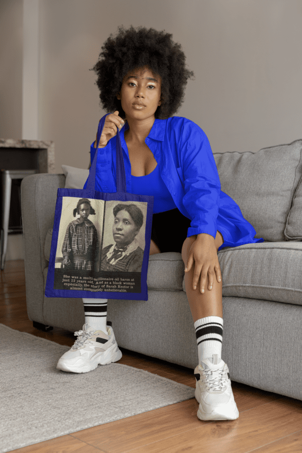 Woman in blue shirt holding tote bag