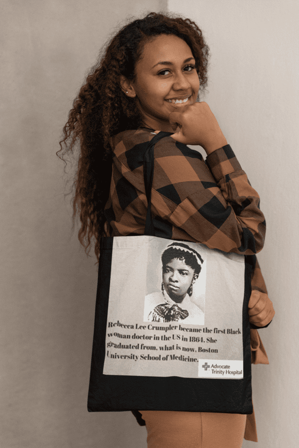 Woman holding a tote bag with a portrait of Rebecca Lee Crumpler, the first Black woman doctor in the U.S.