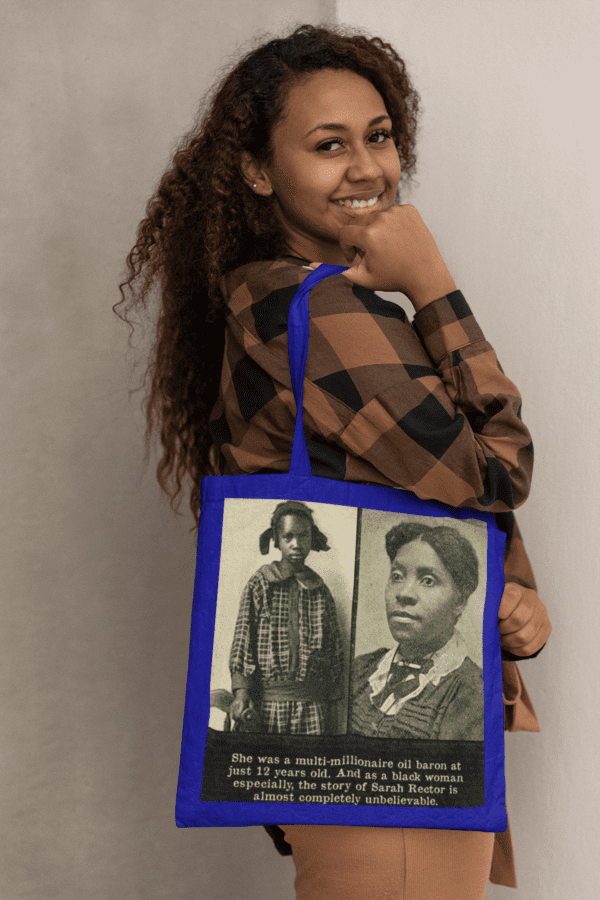 Woman holding a blue tote bag with two women on it.