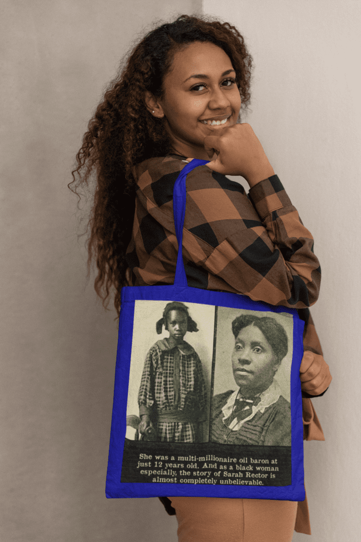 Woman holding a blue tote bag with two women on it.