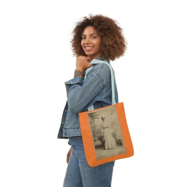 A woman holding an orange bag with a picture of a man.