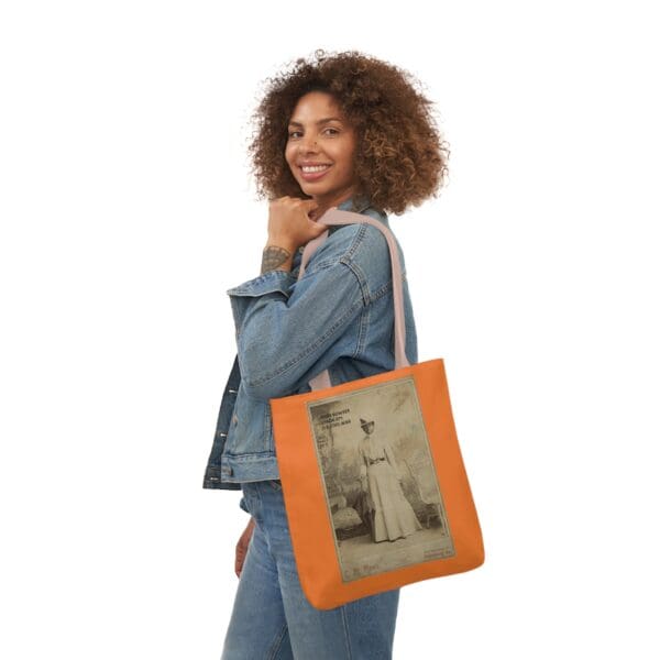 A woman holding an orange bag with a picture of a man.