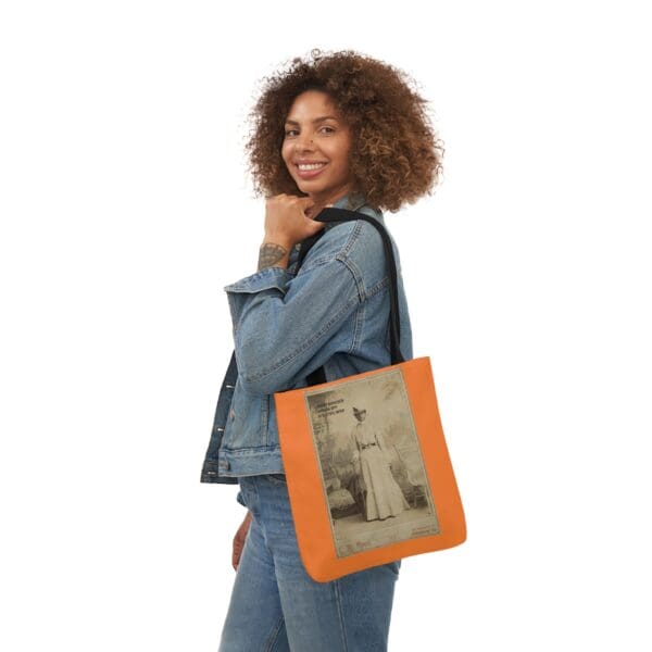 A woman holding an orange bag with a picture of a man.