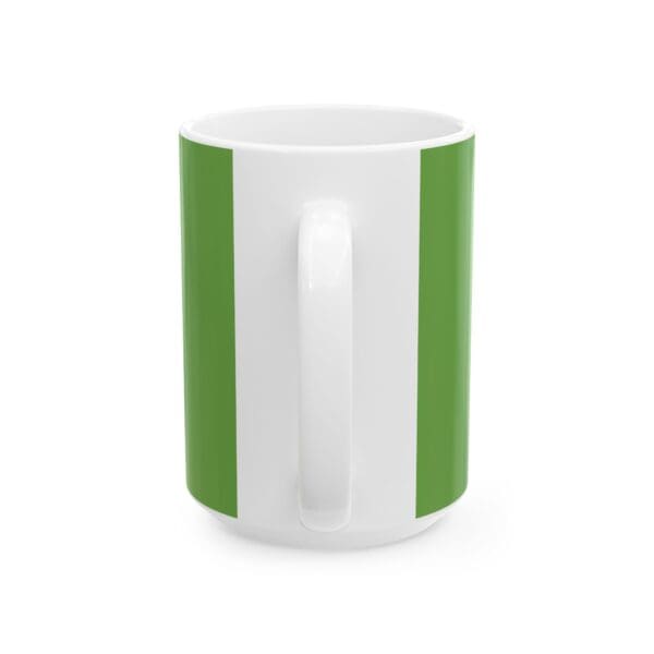 A green and white mug is sitting on the table.