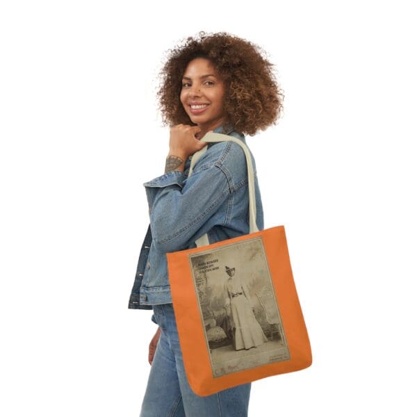 A woman holding an orange bag with a picture of a man.