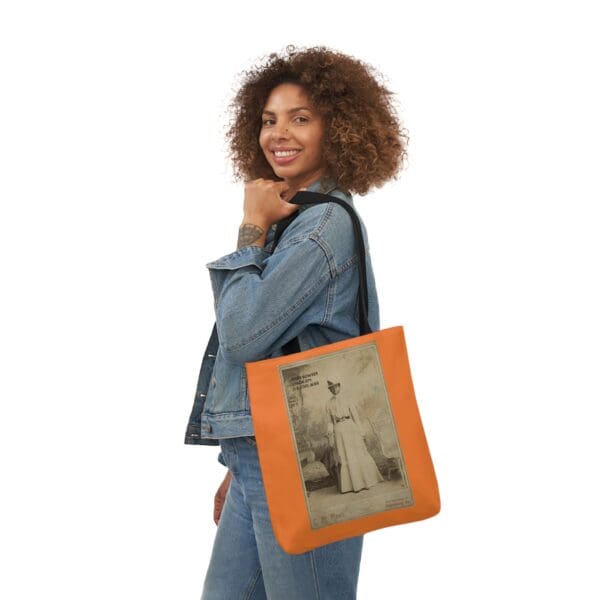 A woman holding an orange bag with a picture of a man.