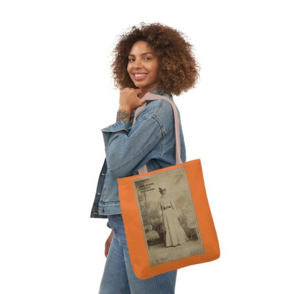 A woman holding an orange bag with a picture of a man.