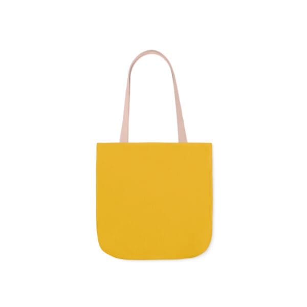 A yellow bag with pink handles and a white handle.