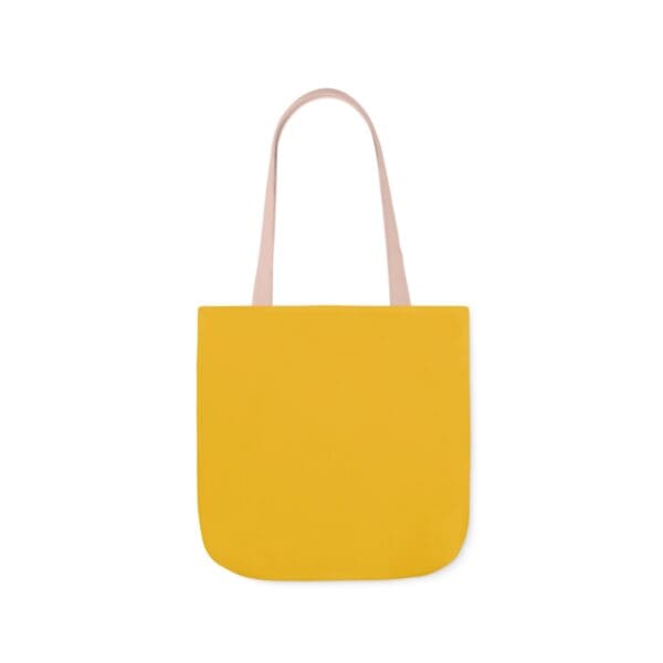 A yellow bag with pink handles and a white handle.