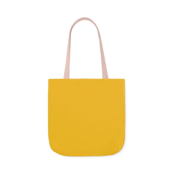 A yellow bag with a pink handle